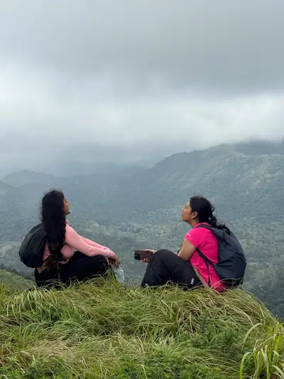 Two friends chatting on the hillside with Western Ghats ranges behind